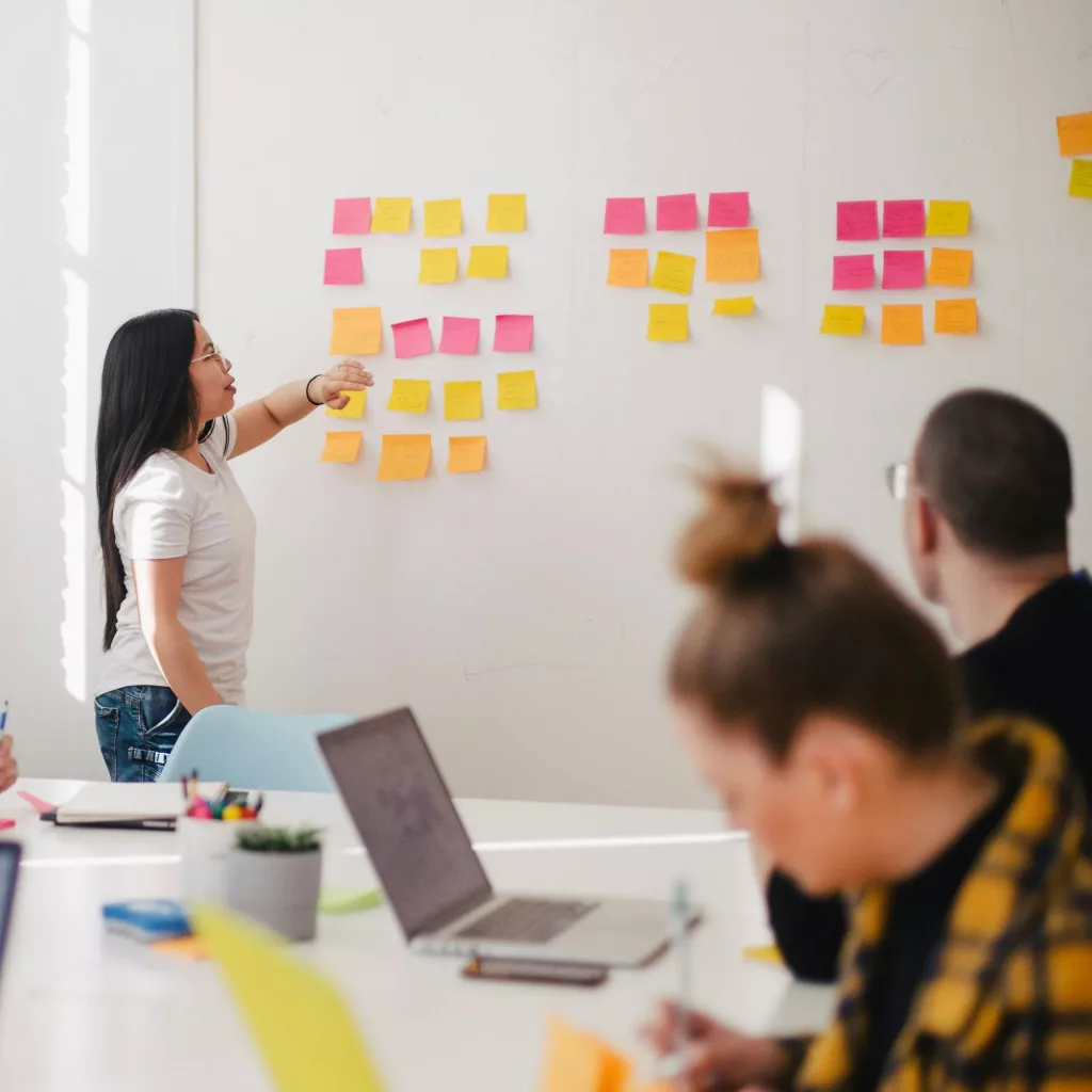 Réunion d'équipe avec post-its sur tableau blanc.